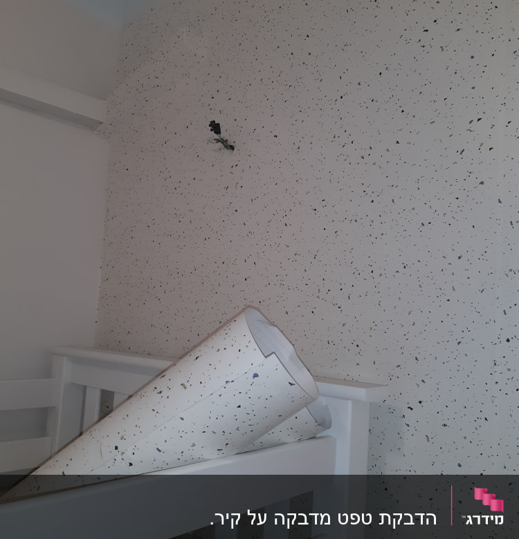 טפט מנוקד על קיר עם גליל טפט מונח